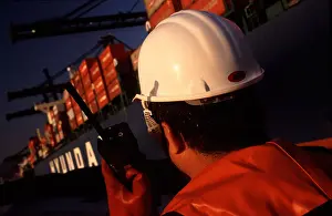 Tugboat Prints: Tugboat worker on radio to containership in kwai chung port hong kong harbour fareast asia sar