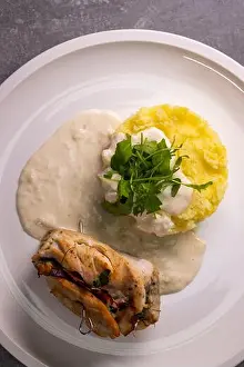 turkey roll filled with spinach and ham served with mashed potatoes and cream sauce
