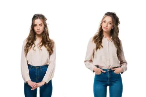 Sisters Prints: twins in trendy shirts and jeans looking at camera isolated on white