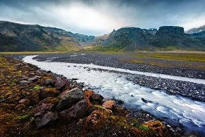 Images Dated 11th June 2016: Typical Iceland landscape with river and mountains. Dramatic sky and red stones on a foreground