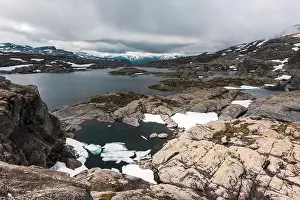 Typical norwegian landscape with snowy mountains and clear lake near the famous Aurlandsvegen (Bjorgavegen), mountain road, Aurland, Norway
