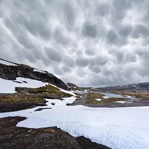 Typical norwegian landscape with snowy mountains and clear lake near the famous Aurlandsvegen (Bjorgavegen), mountain road, Aurland, Norway