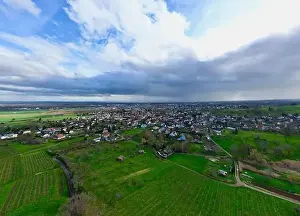Haut Rhin Prints: Uffholtz Winter Wonderland: Verdant Vineyards Embrace a Picturesque Village Amidst Stormy Skies