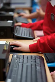 Curriculum Prints: UK primary school ICT lesson with pupils using PC keyboard and mouse