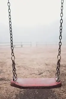 Ukrainian people against war. Scary empty swing at the park with fog in backgroind