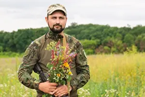 Defend Prints: A Ukrainian soldier with a bouquet of wild flowers as a symbol of Ukraine's victory