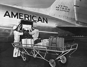 United States: c. 1946 Baggage handlers loading luggage onto an American Airlines DC-3, the FLagship Detroit