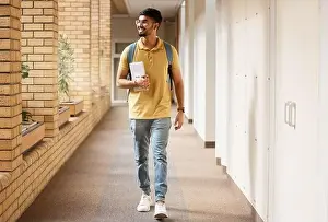 University Student Prints: University student, college and indian man walking with a smile and backpack down campus corridor