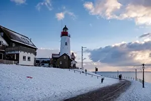Urk Netherlands lighthouse during winter with snow covered coastline