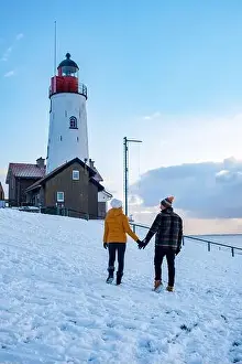 Urk Netherlands lighthouse during winter with snow covered coastline
