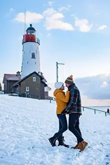 Urk Netherlands lighthouse during winter with snow covered coastline