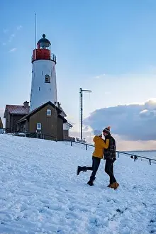 Urk Netherlands lighthouse during winter with snow covered coastline