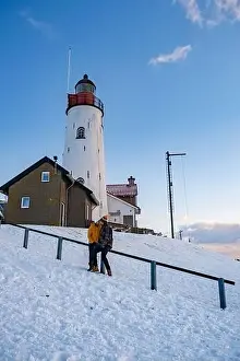 Urk Netherlands lighthouse during winter with snow covered coastline