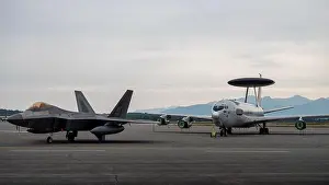A U.S. Air Force F-22 Raptor sits next to an E-3 Sentry Airborne Warning