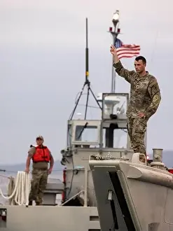 U.S. Army Soldiers signal from a Landing Craft Mechanized after offloading in preparation for Balikatan 23 at Camp