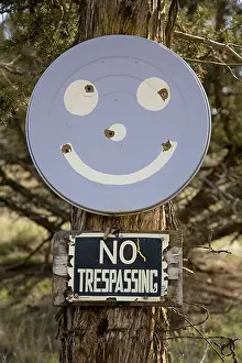 Prohibited Prints: USA OREGON CROOKED RIVER VALLEY A No Trespassing sign and a smiley face with bullet holes in it