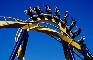 People In The Background Prints: USA, Texas, Dallas, Six Flags Over Texas amusement park, Roller Coaster against blue sky