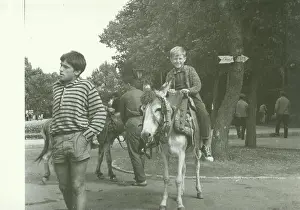Donkey Prints: USSR - CIRCA 1970s: Retro photo shows boy rides on donkey in the park
