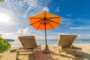 Images Dated 10th December 2015: Vacation in tropical countries. Beach chairs, umbrella and palms on the beach