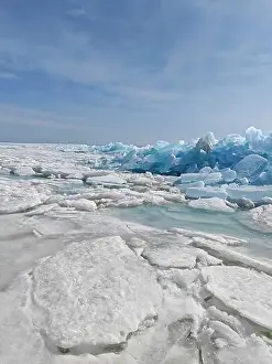Shimmering Prints: Vast icy terrain features large blue icebergs and melting ice sheets reflecting the tranquil arctic environment