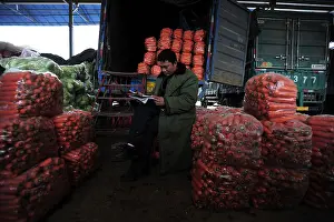 Customers Prints: A vendor waits for customers at a vegetable wholesale market in Wuhan