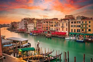 Venice, Italy overlooking boats and gondolas in the Grand Canal at dusk. (Sign reading in Italian No Mafia Venezia e Sacra translates in English to