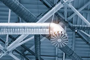 Cooling Prints: Ventilation pipes in silver insulation material hanging from the ceiling inside new building