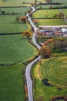 Vertical image long windy road cutting through English Countryside in Cheshire