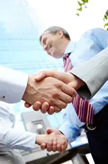 Collar Prints: Vertical image of rows of partners handshaking outdoors on background of modern building