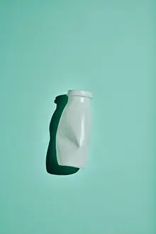 Flat Lay Prints: Vertical minimalistic flat lay shot of white plastic bottle on bluish green background