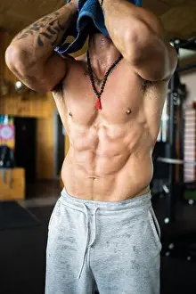 Barbell Prints: Vertical photo of an unrecognizable strong man wiping his sweat with a towel in the gymnasium