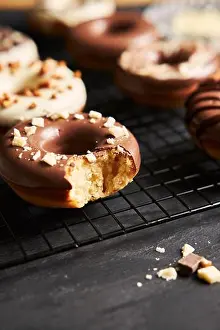 Donut Prints: Vertical shot of delicious donuts covered in the white and brown chocolate glaze on a black table