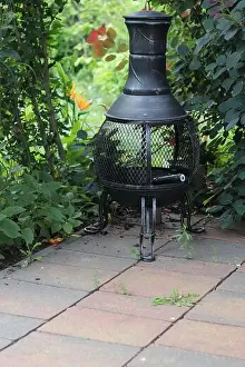 Fireplace Prints: Vertical shot of a fireplace in the shape of an Aztec stove on a terrace in the garden