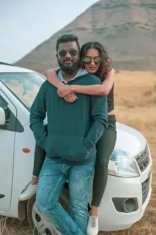 Lean Prints: Vertical shot of a happy young Indian couple, girl hugging her boyfriend from behind