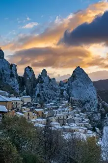 Castelmezzano Prints: Vertical view of Castlemzzano village in winter with a colourful sunrise sky above