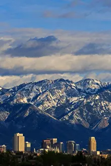 This is a vertical view of the downtown buildings of the Salt Lake City Utah USA with the snow-capped Wasatch Mountains