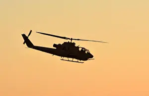 Chopper Prints: Vietnam War era army helicopter flying at sunset side view