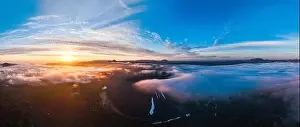 View from above, stunning aerial view of Hverfjall volcano at sunset surrounded by beautiful fluffy clouds
