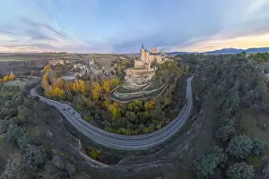 Top view of aerial view of medieval castle Alcazar of Segovia Spain located on hill with autumn trees next to