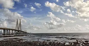 Stone Island Prints: Bottom view to Bandra Worli Sea Link bridge through the rocky beach under fluffy clouds