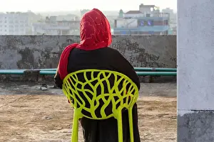 Veil Prints: Back view of a Bangladeshi Muslim woman wearing a black Abaya and maroon Veil/Hijab