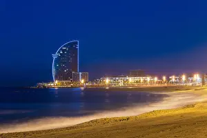 View of Barcelona Beach in summer night along seaside in Barcelona, Spain. Mediterranean Sea in Spain