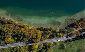 Late Summer Prints: Top View of a beach nearby trees and a road with driving cars in autumn