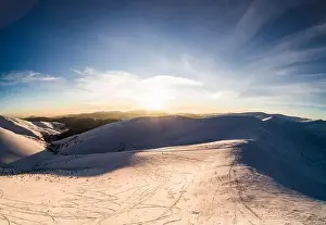 Hill Glacier Prints: Top view of a beautiful mesmerizing view of the ski slope with ski trails located in the mountains on a sunny winter