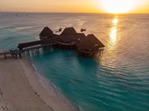 Tanzania Prints: Top View on Beautiful thatch stilt house restaurant at Zanzibar Kendwa beach at evening time in Turquoise Water of