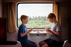 On The Move Prints: Side view of boys playing cards while traveling in train, Thailand, Asia