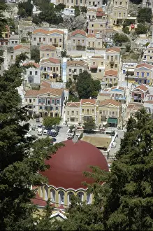 Holiday House Prints: View of the city with its colourful ochre houses and the red dome of a Greek Orthodox church of Symi Greece