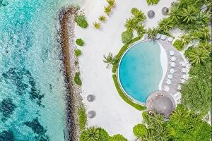 Images Dated 26th May 2019: Top view from drone at beach, azure sea and poolside with palm tree in Maldives luxury resort