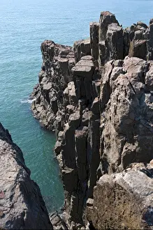 Basalt Prints: View of emerald green ocean high above jagged