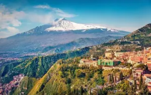 View from flying drone. Beautiful morning view of Taormina town and Etna volcano on background
